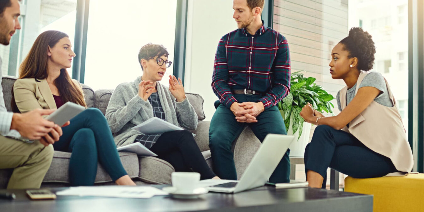 employees discussing workplace mental health benefits during a team wellness meeting