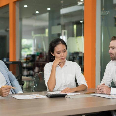 Benefits professionals reviewing employee benefit plans and ERISA fiduciary responsibilities during a corporate meeting.